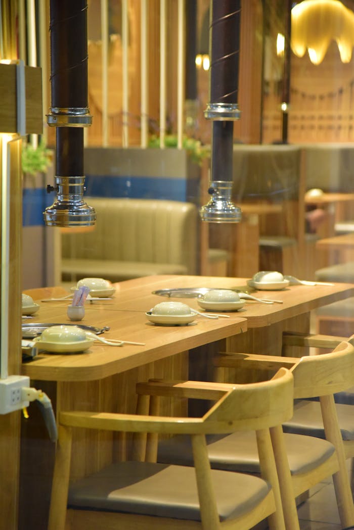 A cozy restaurant interior with a set dining table, ready for guests. Warm and inviting ambiance.